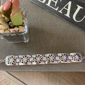 silver bracelet with floral accents and diamonds.